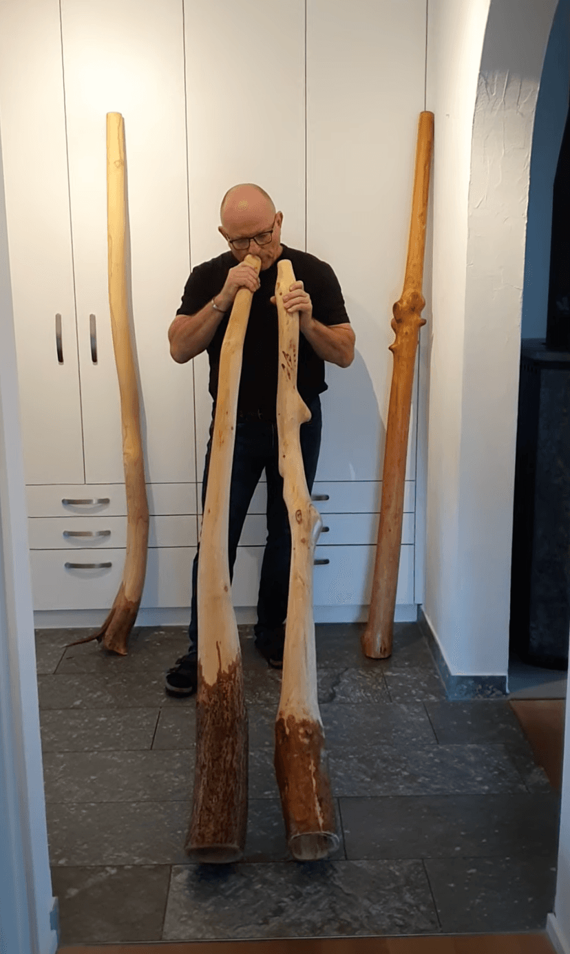 Porträt: Mann mit Didgeridoos, handgefertigt aus Holz